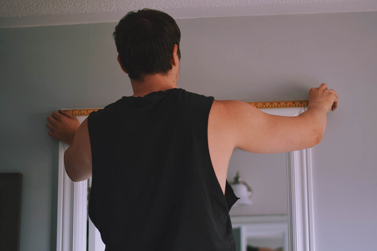 man measuring kitchen door frame