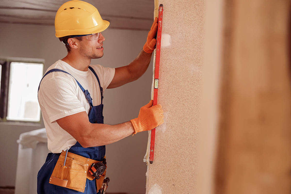 builder measuring wall before installing kitchen doors
