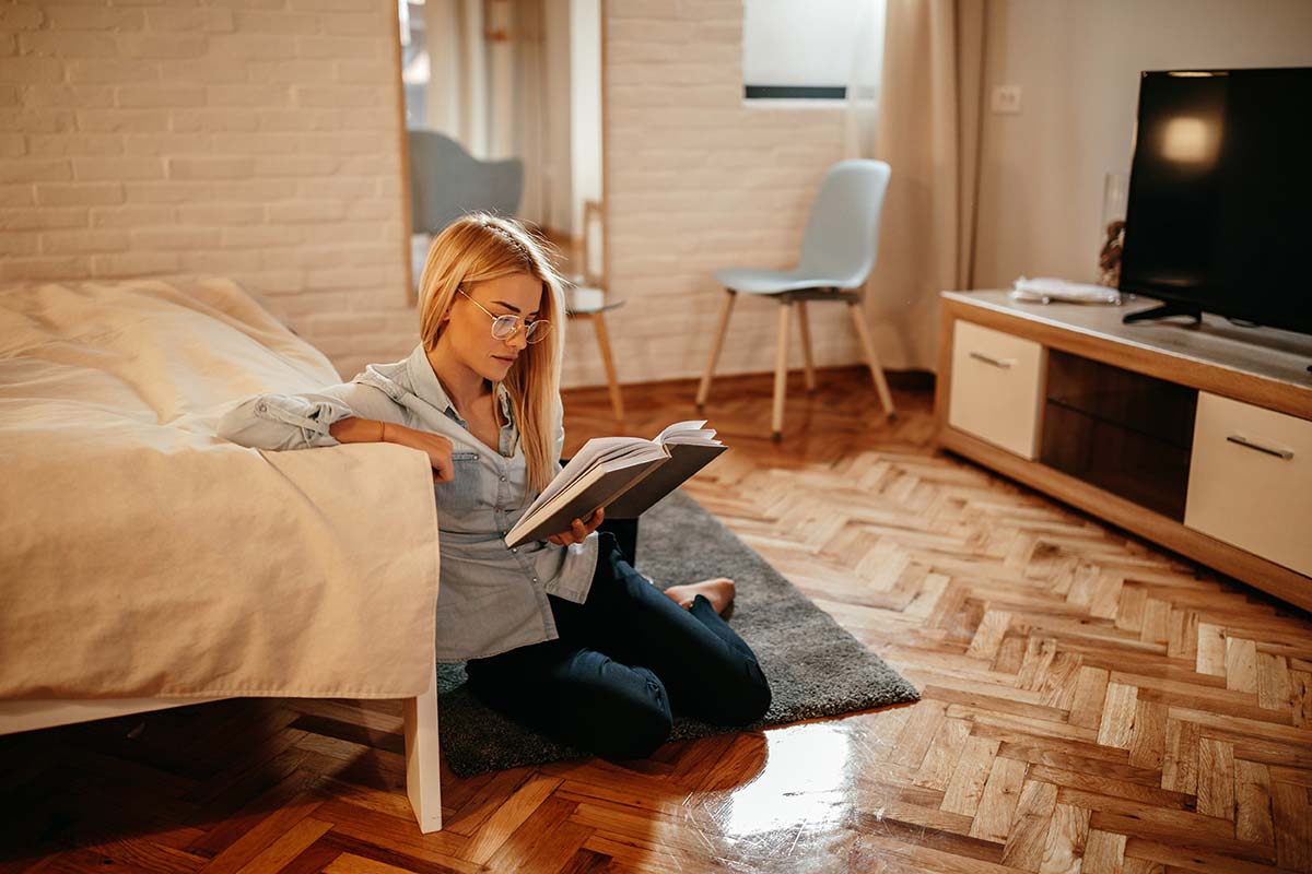 woman sitting in her master bedroom on a new wooden floor