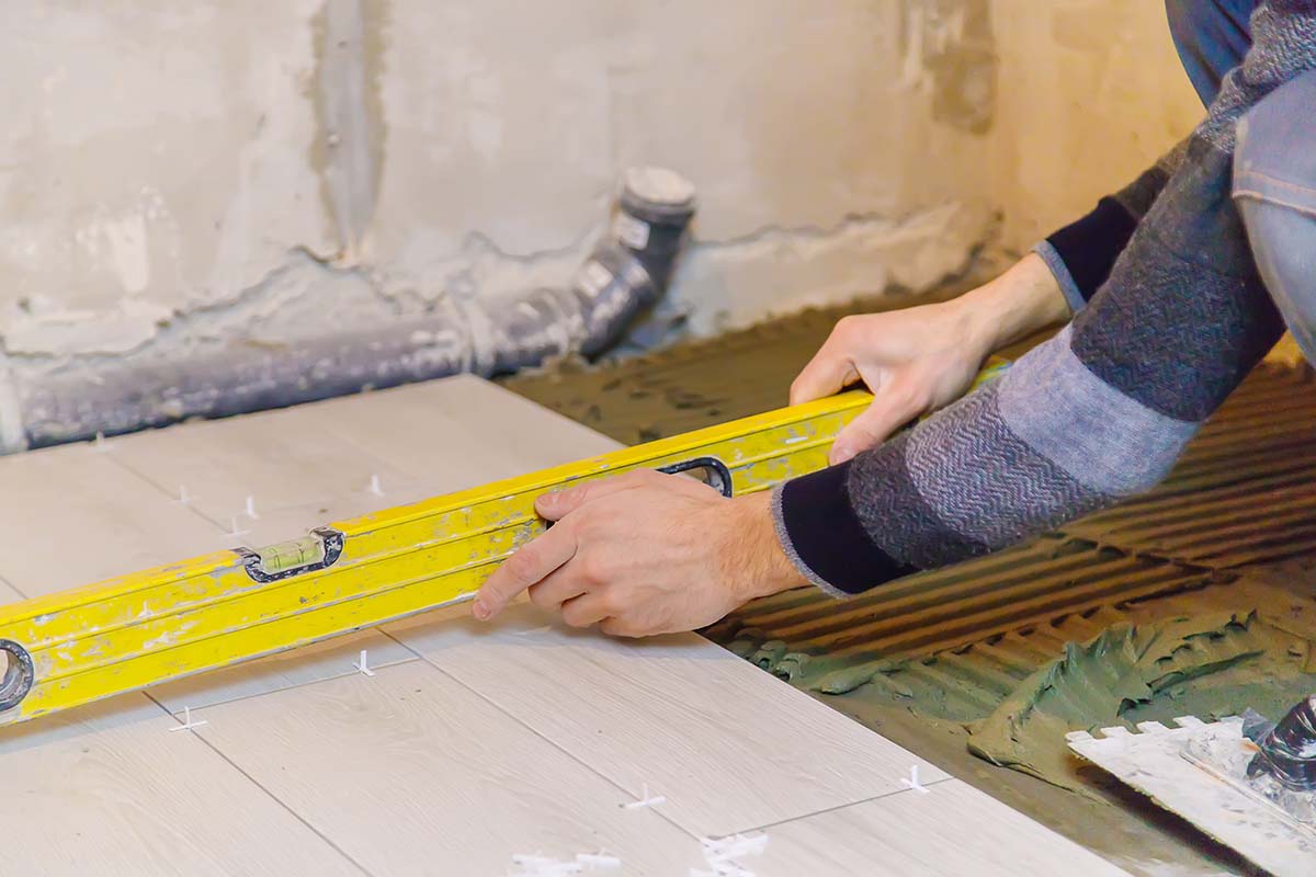 kitchen fitter measuring floor tiles