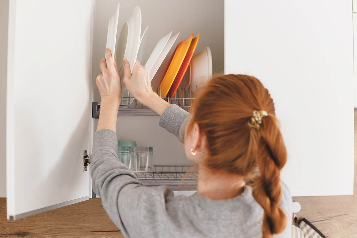 woman opening kitchen cabinet door