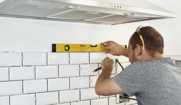 kitchen builder tiling a wall